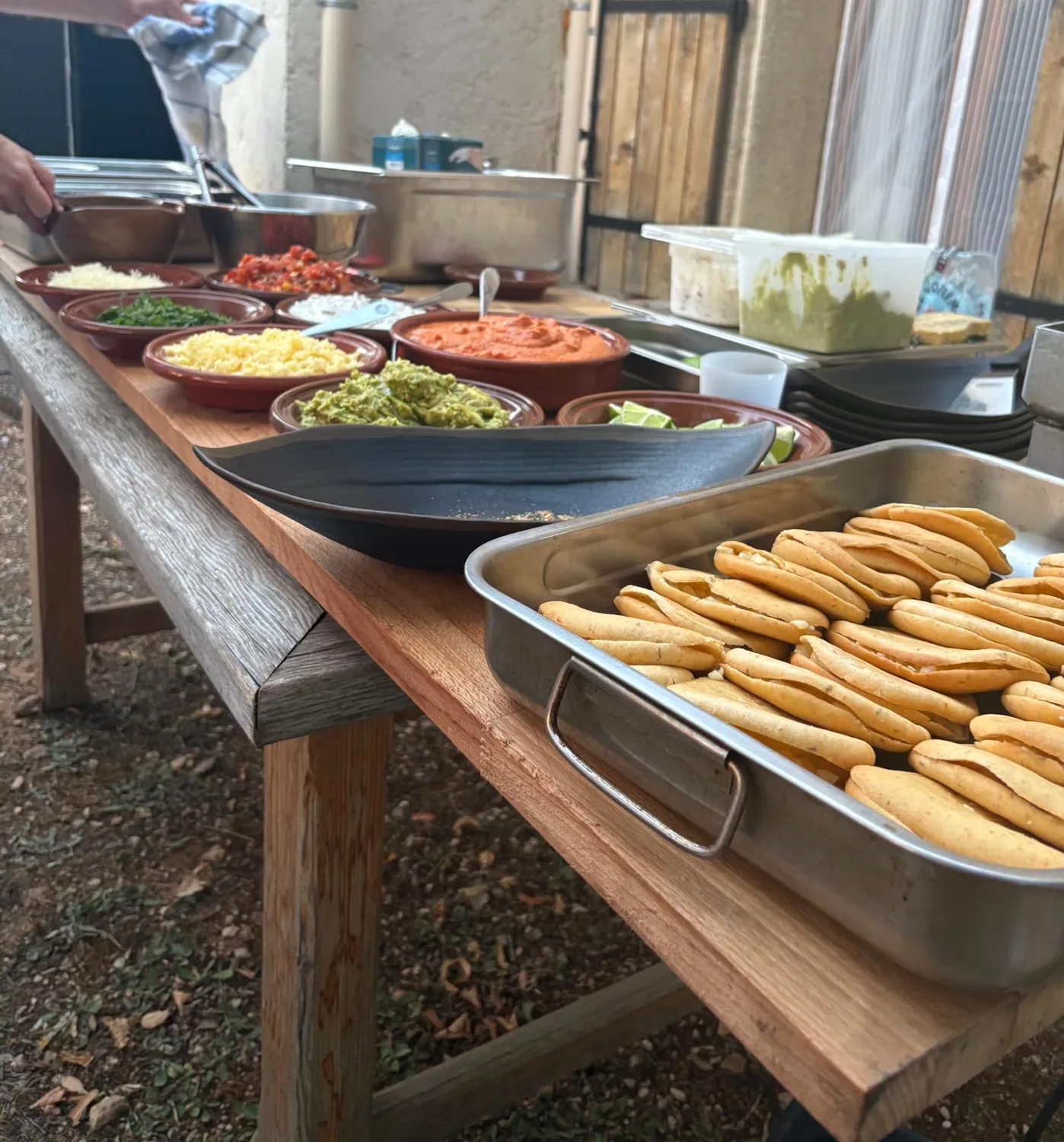 Pains et garnitures disposés sur un buffet extérieur.