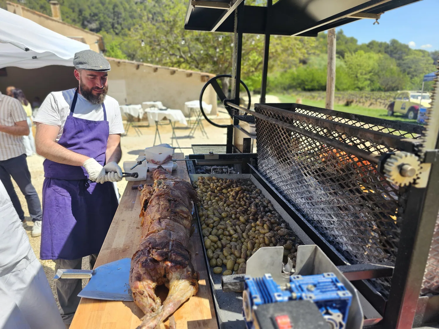 Découpe d’une viande rôtie auprès d’un plat de pommes de terre.